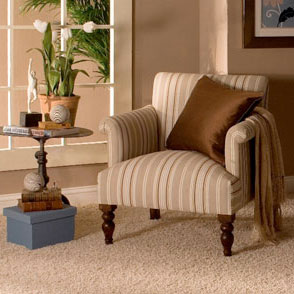 Upholstered chair and pillow on carpet in foyer.